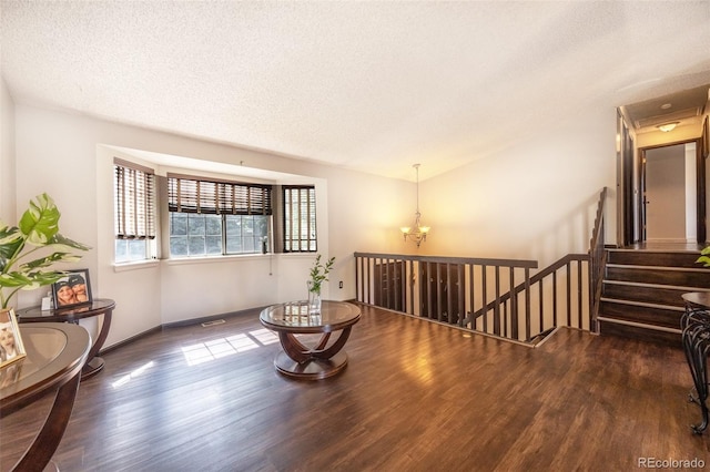 4362 Nepal St, Denver, CO 80249 - sitting room featuring wood finished floors, a textured ceiling, a chandelier, and an upstairs landing