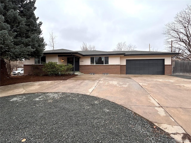 single story home with a garage, driveway, brick siding, and fence