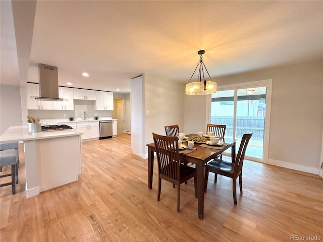 dining space with light wood finished floors, recessed lighting, baseboards, and an inviting chandelier