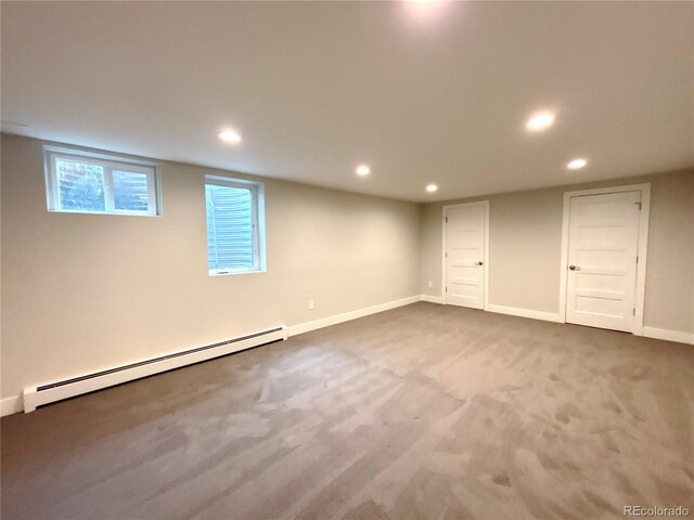 basement featuring a baseboard heating unit, recessed lighting, carpet flooring, and baseboards