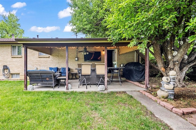 12167 E Exposition Ave, Aurora, CO 80012 - rear view of property with brick siding, outdoor lounge area, a yard, a patio, and a ceiling fan