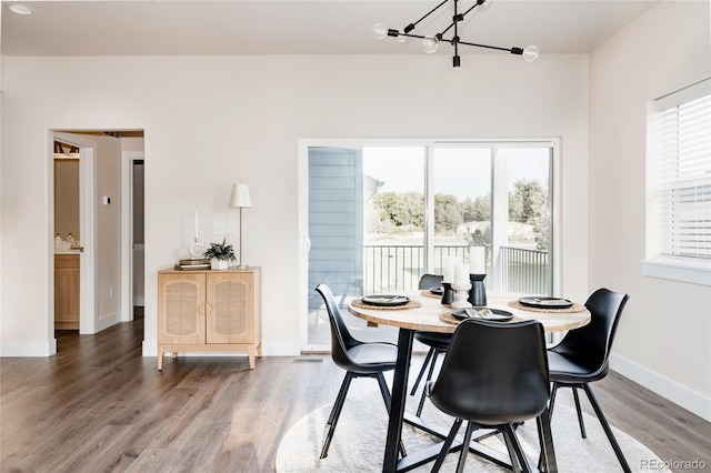 dining area featuring an inviting chandelier and hardwood / wood-style flooring