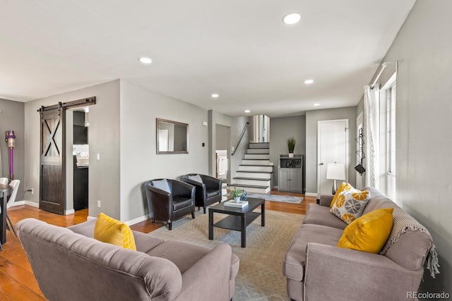 living room featuring recessed lighting, stairs, a barn door, and wood finished floors