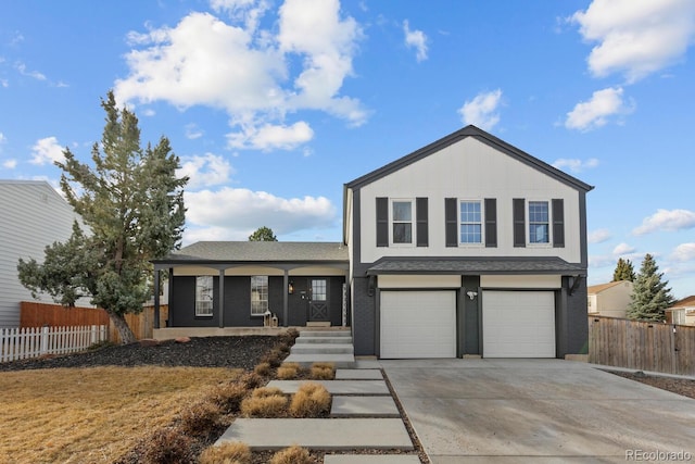 traditional home featuring a porch, fence, a garage, and driveway