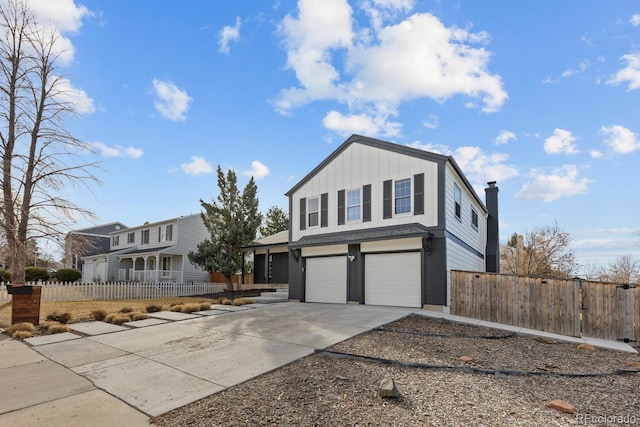 view of front facade with fence, a garage, and driveway