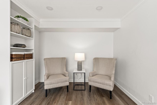 living area with baseboards, wood finished floors, and crown molding