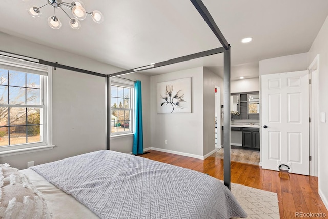 bedroom featuring recessed lighting, baseboards, multiple windows, and hardwood / wood-style floors