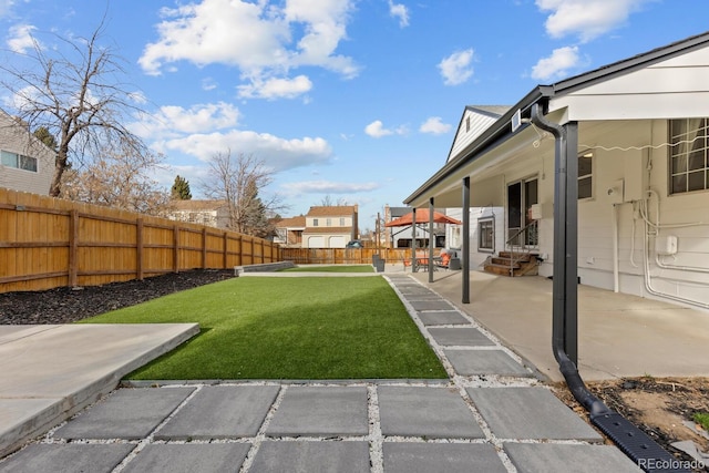 view of yard featuring a patio, a fenced backyard, and entry steps