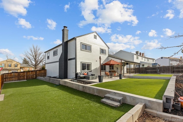 back of property with a patio, a lawn, and a fenced backyard