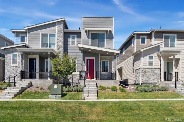 view of front of home with central AC unit, stone siding, and a front yard