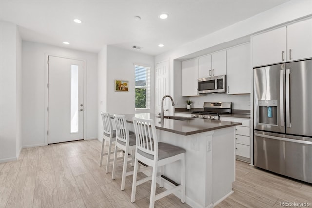 kitchen featuring a sink, visible vents, recessed lighting, dark countertops, and appliances with stainless steel finishes