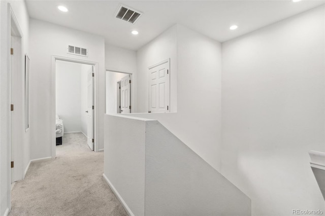 corridor with recessed lighting, visible vents, and light colored carpet