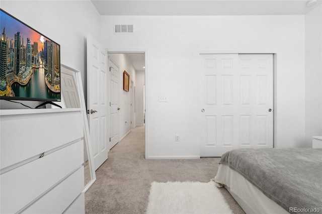 bedroom with a closet, light carpet, baseboards, and visible vents
