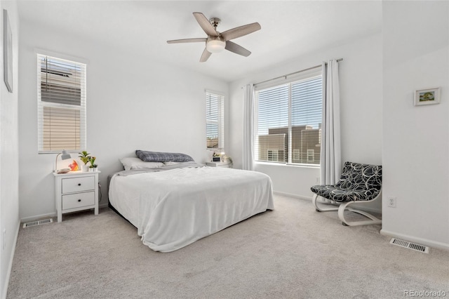 carpeted bedroom with baseboards, a ceiling fan, and visible vents
