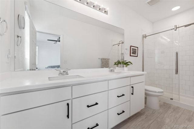 full bath with a sink, double vanity, toilet, and a stall shower