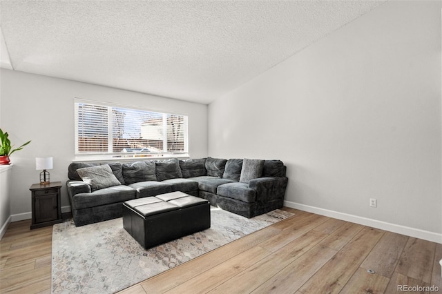 living room featuring light wood-type flooring and a textured ceiling