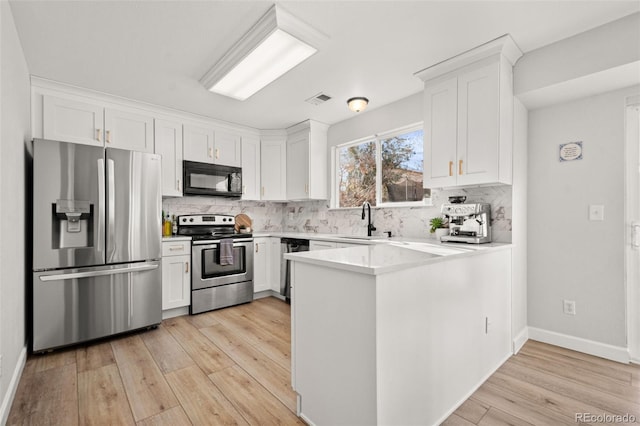 kitchen with tasteful backsplash, white cabinetry, sink, and stainless steel appliances