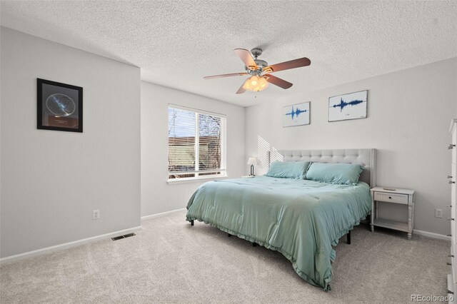 bedroom featuring ceiling fan, carpet, and a textured ceiling