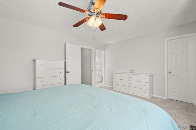 carpeted bedroom featuring ceiling fan and a textured ceiling