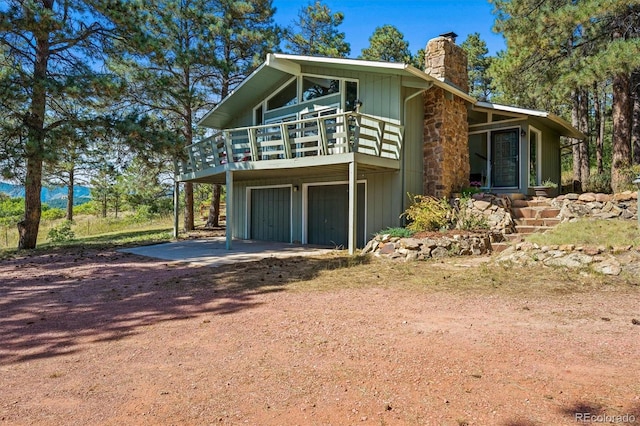 view of property exterior featuring a garage and a wooden deck