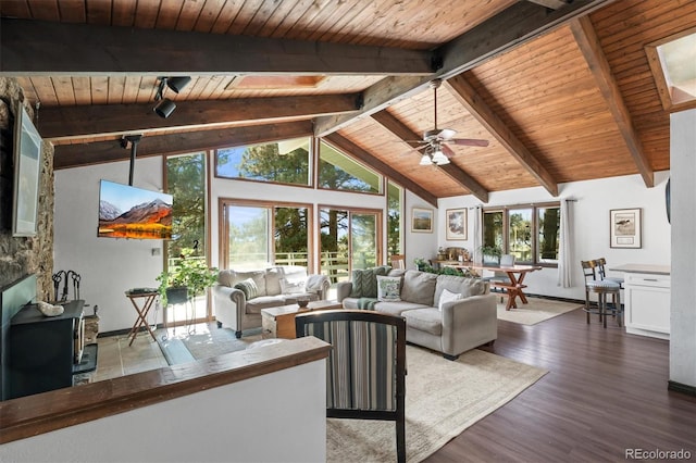 living room with ceiling fan, dark hardwood / wood-style floors, a healthy amount of sunlight, and lofted ceiling with beams