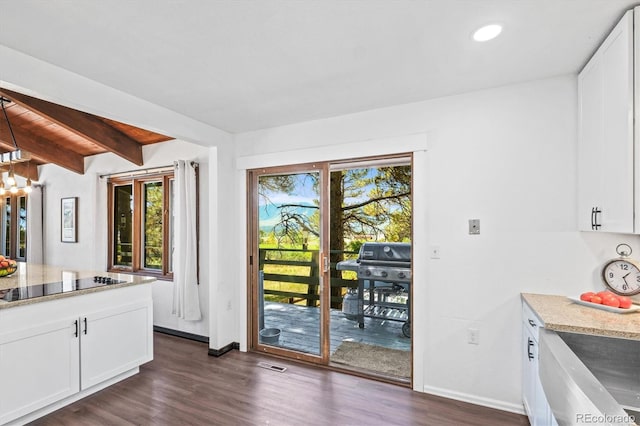 kitchen featuring lofted ceiling with beams, white cabinetry, dark hardwood / wood-style flooring, and black electric cooktop