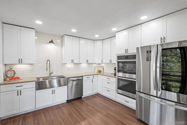 kitchen featuring stainless steel appliances, dark hardwood / wood-style floors, white cabinets, and sink