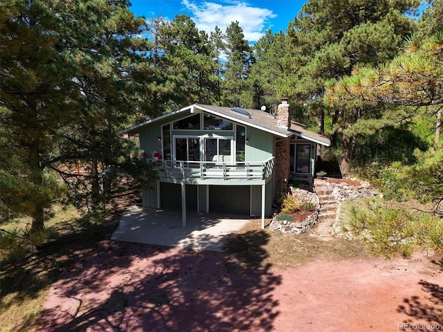 rear view of property featuring a wooden deck