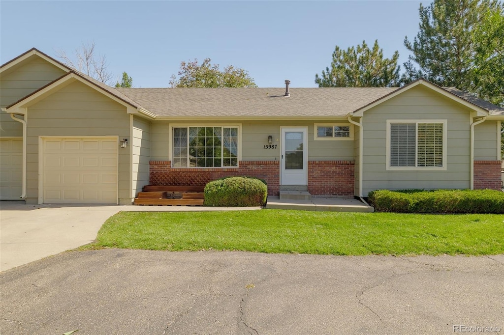 single story home featuring a garage and a front lawn