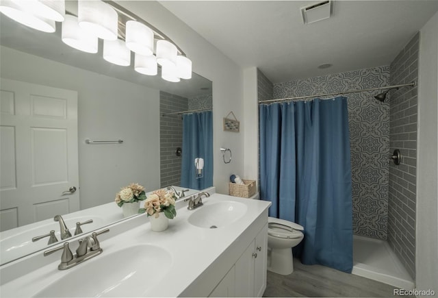 11030 Pine Meadows Rd, Colorado Springs, CO 80908 - bathroom with tiled shower, double vanity, and wood finished floors
