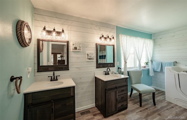 11030 Pine Meadows Rd, Colorado Springs, CO 80908 - bathroom featuring wooden walls, wood finished floors, two vanities, and a tub