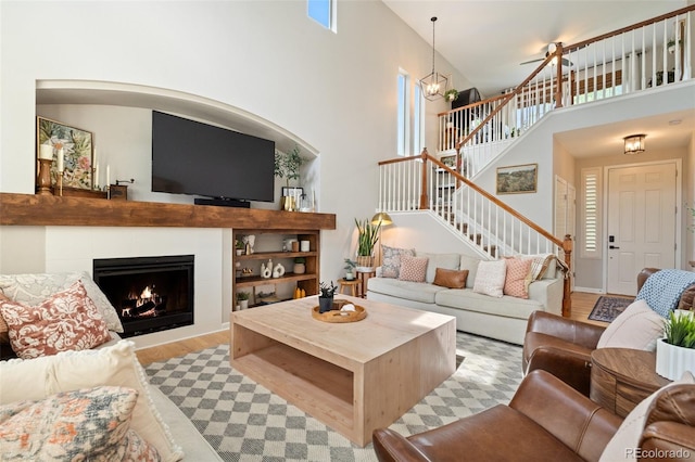 7853 S Jasper Way, Englewood, CO 80112 - living area with plenty of natural light, stairs, a high ceiling, wood finished floors, and a lit fireplace