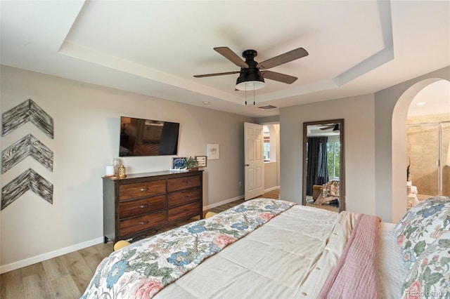7853 S Jasper Way, Englewood, CO 80112 - bedroom featuring a raised ceiling, arched walkways, wood finished floors, ceiling fan, and access to outside