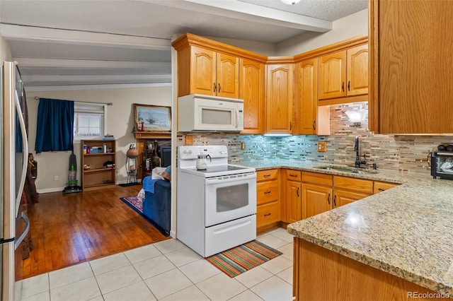 7260 Otis Ct, Arvada, CO 80003 - kitchen with white appliances, tasteful backsplash, light stone counters, and light tile patterned floors