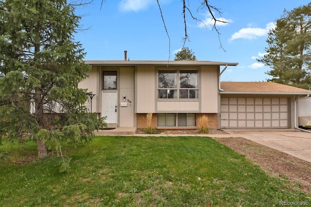 view of front of property featuring a front lawn, driveway, brick siding, and an attached garage