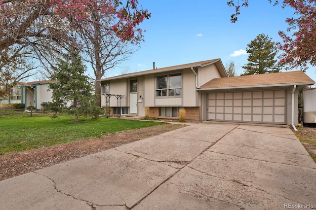 raised ranch with a front yard, concrete driveway, brick siding, and a garage