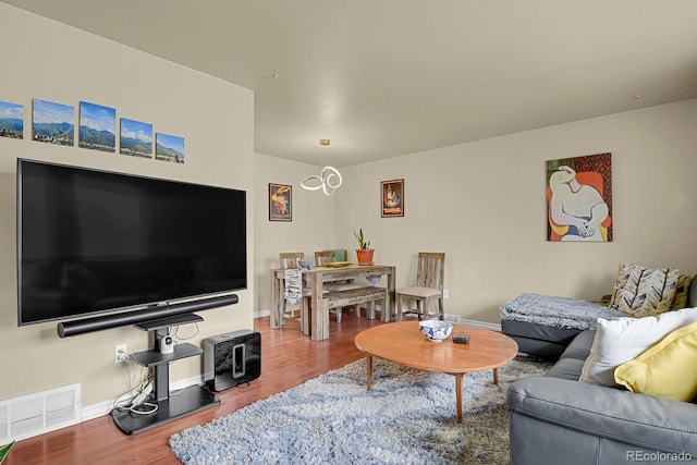 living room with baseboards, visible vents, and wood finished floors