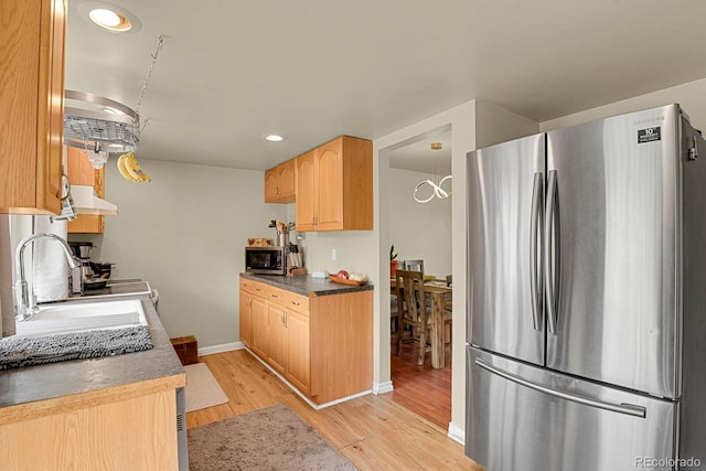 kitchen with light brown cabinetry, a sink, stainless steel appliances, light wood-type flooring, and recessed lighting