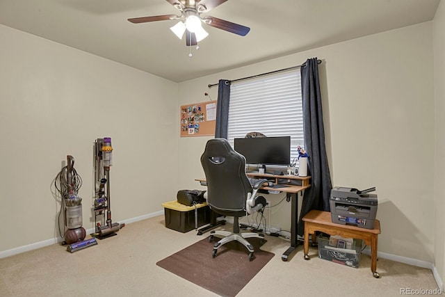 carpeted office space featuring baseboards and ceiling fan