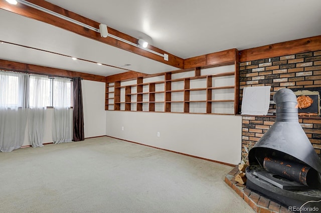 interior space with a wood stove, baseboards, beamed ceiling, and carpet floors