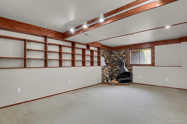 interior space with a wood stove, carpet, visible vents, and baseboards
