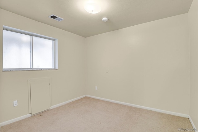 unfurnished room with light colored carpet, baseboards, and visible vents