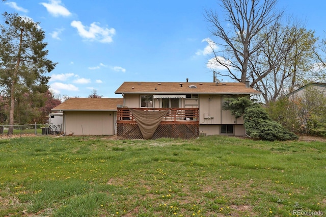 rear view of property featuring a yard, a deck, and fence