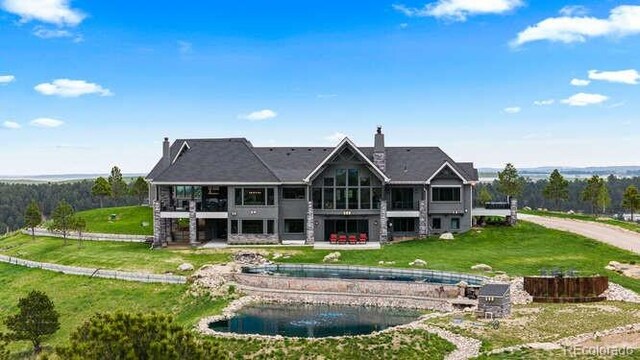 15295 E Cherry Creek S Road, Larkspur, CO 80118 - rear view of property featuring a swimming pool, a chimney, a lawn, a balcony, and a sunroom