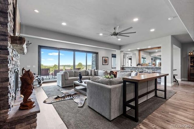 15295 E Cherry Creek S Road, Larkspur, CO 80118 - living room with ceiling fan, wood finished floors, a stone fireplace, and recessed lighting
