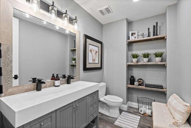 15295 E Cherry Creek S Road, Larkspur, CO 80118 - bathroom featuring toilet, vanity, and wood finished floors