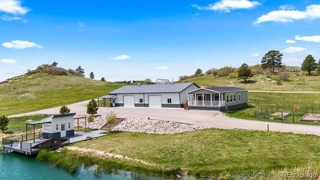15295 E Cherry Creek S Road, Larkspur, CO 80118 - rear view of property with a garage, a yard, and a water view