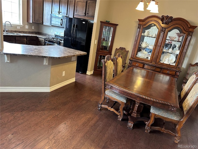 4746 Raven Run, Broomfield, CO 80023 - dining space with dark wood-type flooring, baseboards, and a chandelier
