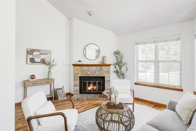 2040 S Xenia Way, Denver, CO 80231 - living room featuring vaulted ceiling, a fireplace, wood finished floors, and a textured ceiling