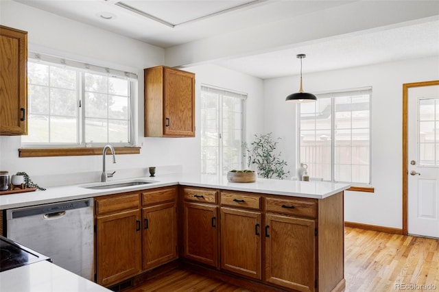 2040 S Xenia Way, Denver, CO 80231 - kitchen with dishwasher, a peninsula, brown cabinetry, light countertops, and light wood finished floors